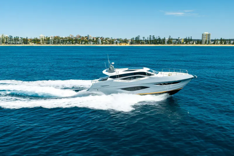 Impulse Yacht Photos Pics 2017 Numarine 62 Hardtop yacht cruising on blue ocean near city skyline.