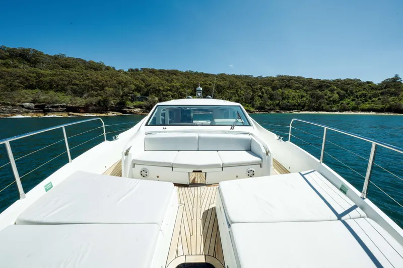 Impulse Yacht Photos Pics 2017 Numarine 62 Hardtop yacht with sunbeds, cruising near lush coastline.