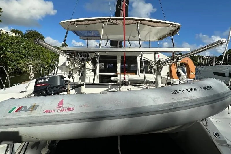 Nacrite Yacht Photos Pics 2018 Lagoon 380 catamaran with dinghy and Yamaha motor, docked under clear blue sky.