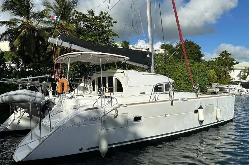 Nacrite Yacht Photos Pics 2018 Lagoon 380 catamaran docked by tropical trees and calm water.