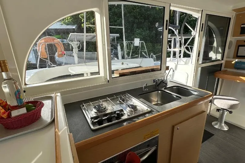Nacrite Yacht Photos Pics Interior of 2018 Lagoon 380 catamaran featuring a compact kitchen with stove and sink.