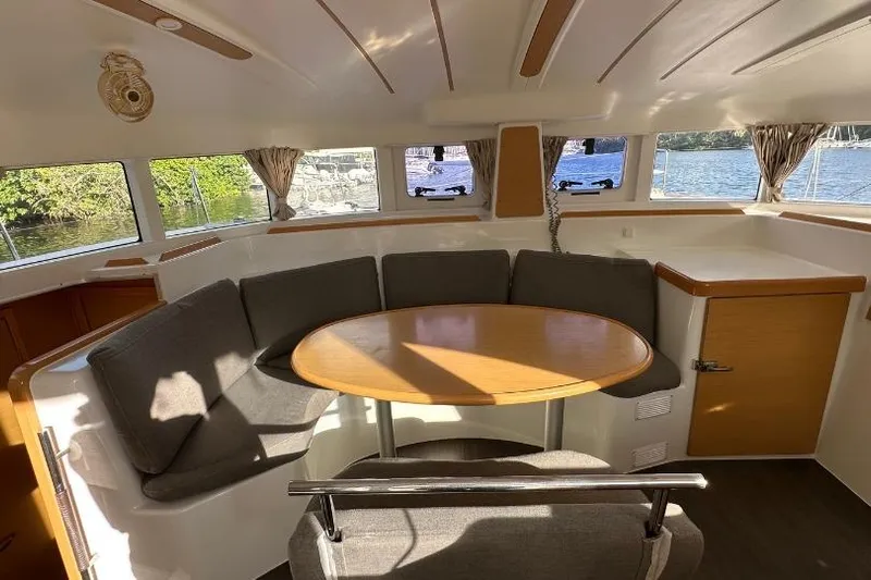 Nacrite Yacht Photos Pics Interior of 2018 Lagoon 380 catamaran with round table and cushioned seating.