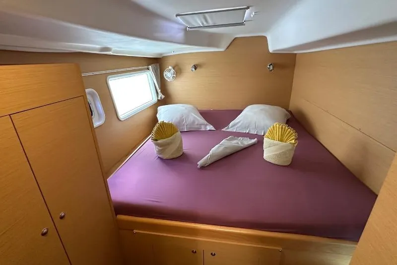 Nacrite Yacht Photos Pics Cozy cabin interior of 2018 Lagoon 380 catamaran with neatly arranged bed and wooden finish.