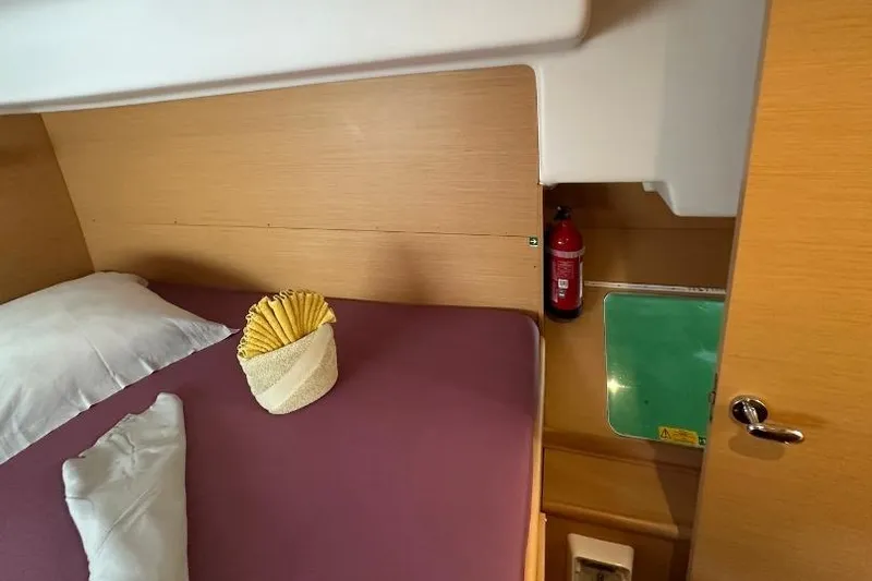 Nacrite Yacht Photos Pics Cozy cabin interior of 2018 Lagoon 380 catamaran with bed and fire extinguisher.