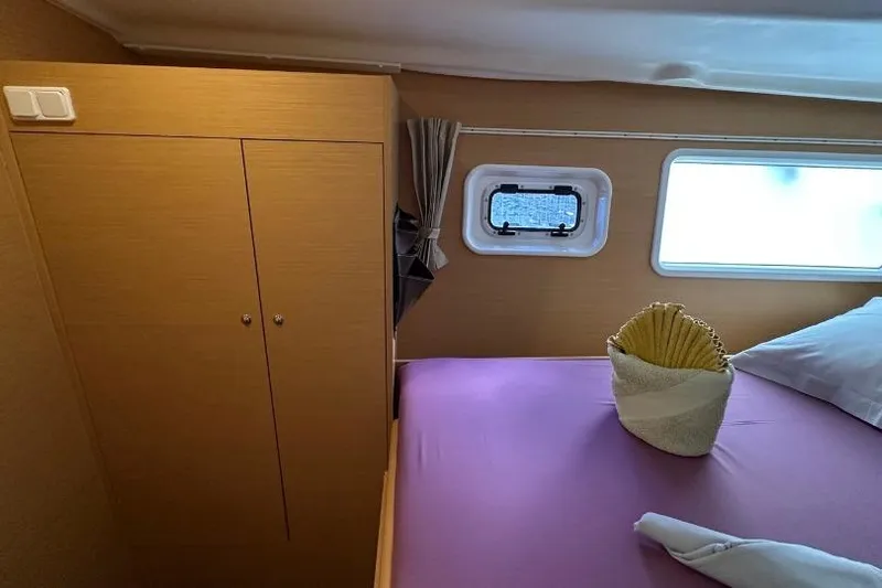 Nacrite Yacht Photos Pics Cabin interior of 2018 Lagoon 380 catamaran with bed, window, and storage.