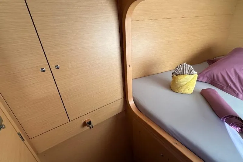 Nacrite Yacht Photos Pics Cozy cabin interior of 2018 Lagoon 380 catamaran with neatly arranged bed and wooden cabinetry.