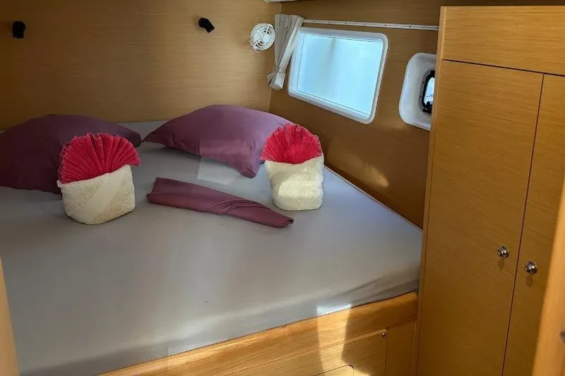 Nacrite Yacht Photos Pics Cozy cabin interior of 2018 Lagoon 380 catamaran with neatly arranged bed and pillows.
