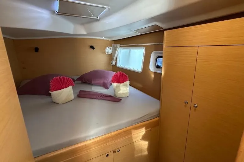 Nacrite Yacht Photos Pics Cozy cabin interior of 2018 Lagoon 380 catamaran with neatly arranged bed and wooden cabinetry.
