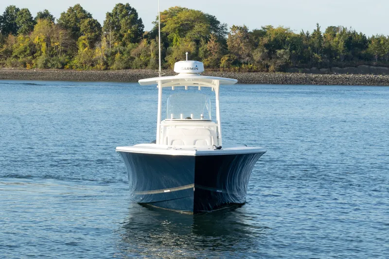 Resolute Yacht Photos Pics 2017 Regulator 31 boat on calm water with forested shoreline background.