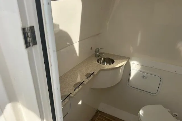 Resolute Yacht Photos Pics 2017 Regulator 31 boat interior with sink and toilet in compact bathroom.