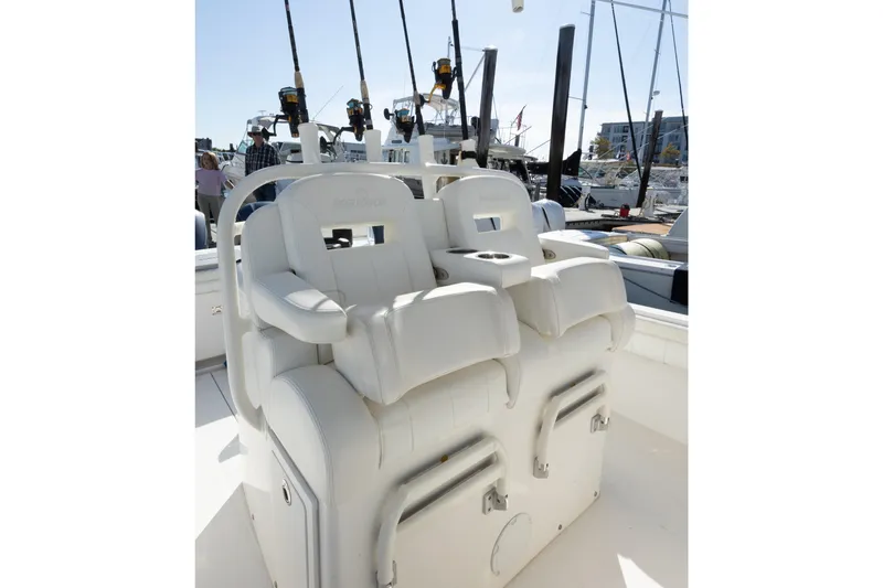 Resolute Yacht Photos Pics 2017 Regulator 31 boat with white cushioned seating and fishing rods in a marina setting.