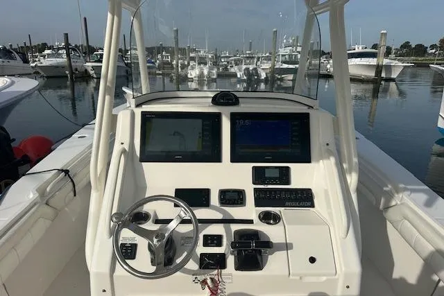 Resolute Yacht Photos Pics Cockpit view of a 2017 Regulator 31 boat with navigation screens and steering wheel.