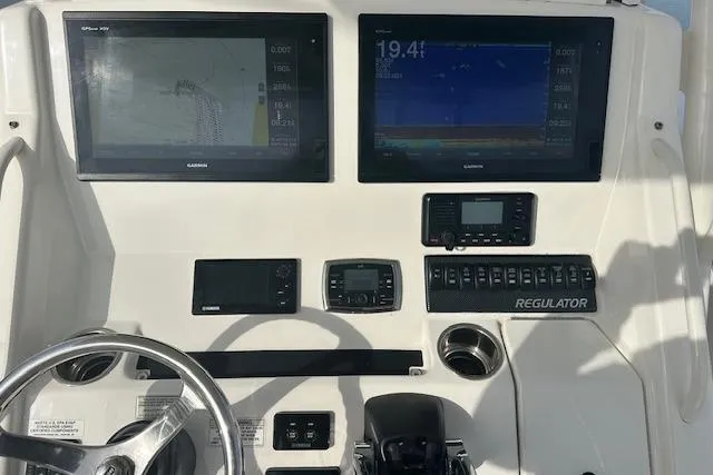Resolute Yacht Photos Pics Control panel of a 2017 Regulator 31 boat with Garmin displays and steering wheel.