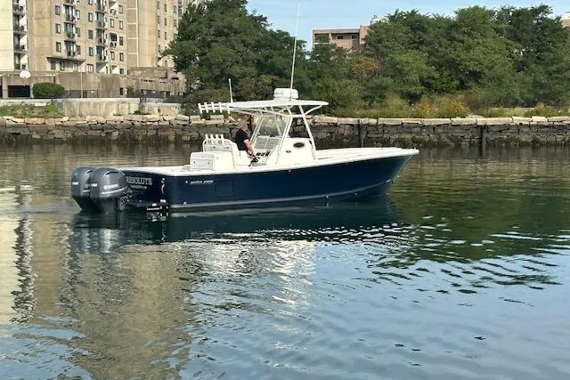 Resolute Yacht Photos Pics 2017 Regulator 31 boat on calm water near urban shoreline.