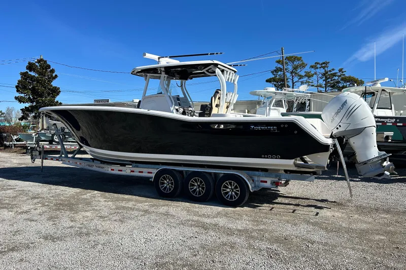  Yacht Photos Pics 2020 Tidewater 320 CC Adventure boat on trailer, parked outdoors under clear blue sky.