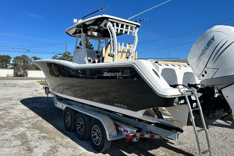  Yacht Photos Pics 2020 Tidewater 320 CC Adventure boat on trailer with Mercury engines, parked outdoors.