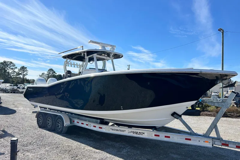  Yacht Photos Pics 2020 Tidewater 320 CC Adventure boat on trailer under clear blue sky.