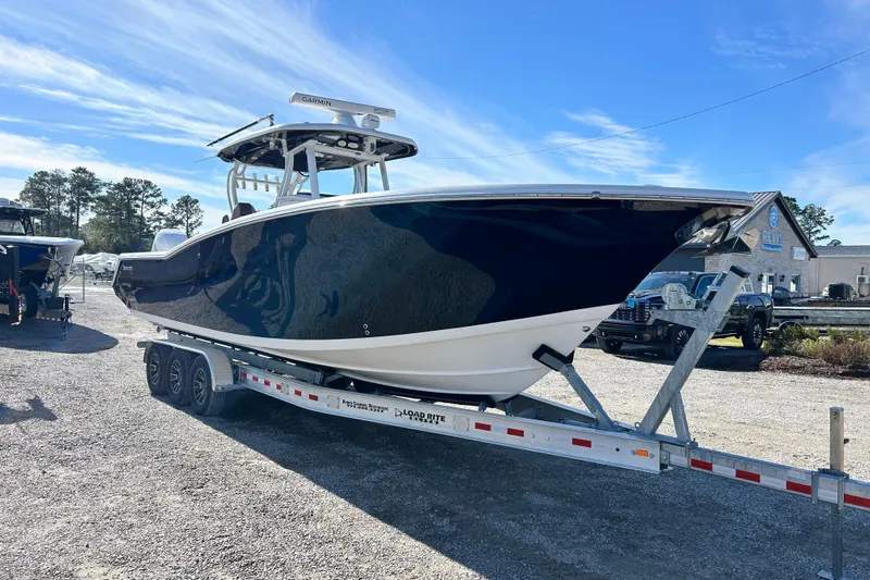  Yacht Photos Pics 2020 Tidewater 320 CC Adventure boat on trailer under clear blue sky.