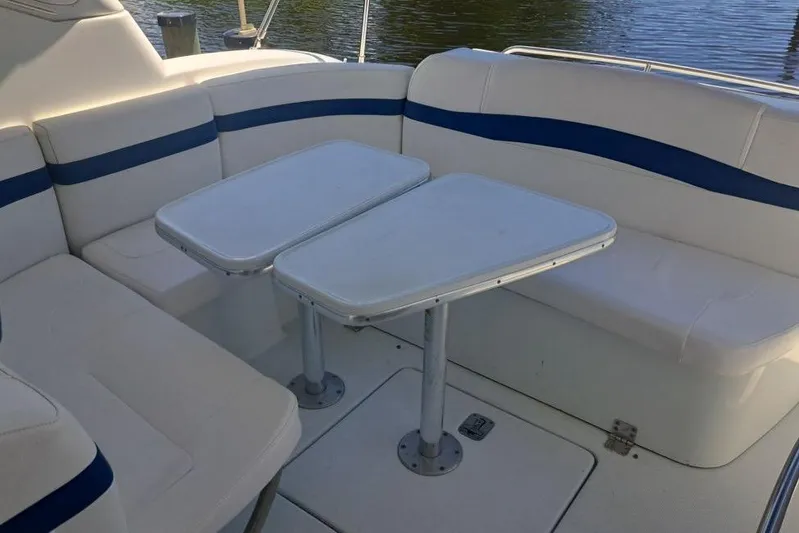Wattever Yacht Photos Pics 2008 Formula 34 Performance Cruiser seating area with dual tables, white and blue upholstery.