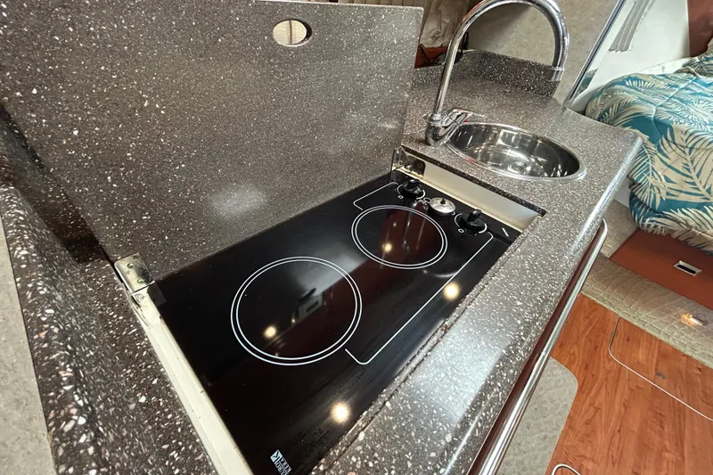 Wattever Yacht Photos Pics 2008 Formula 34 Performance Cruiser kitchen with stove and sink, featuring sleek countertops.