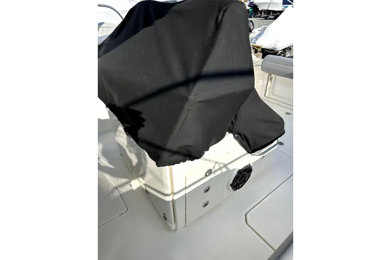  Yacht Photos Pics 2023 Boston Whaler OUTRAGE boat interior with covered console and seating area.