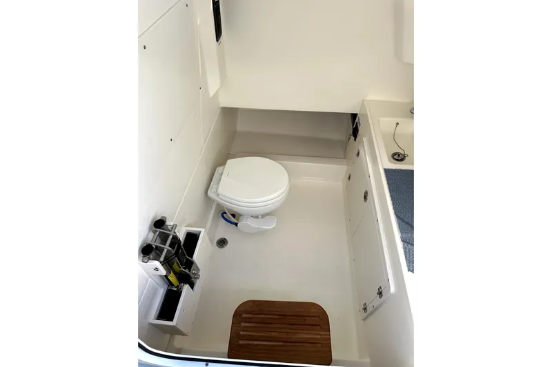  Yacht Photos Pics 2023 Boston Whaler OUTRAGE boat interior with toilet and storage compartments.