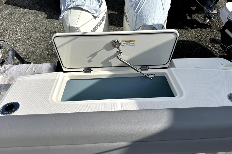  Yacht Photos Pics 2023 Boston Whaler OUTRAGE boat with open storage compartment, showcasing sleek design.