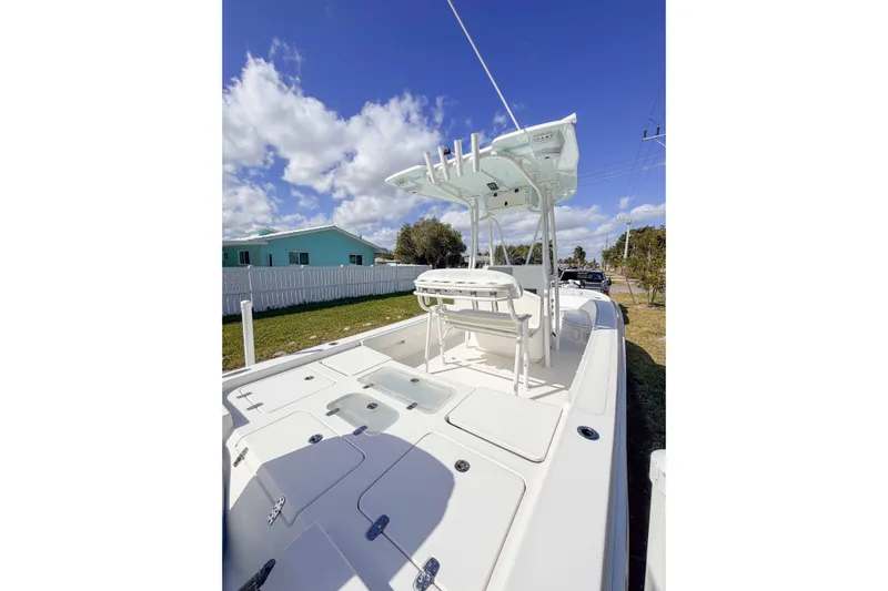  Yacht Photos Pics 2023 Contender 26 Bay boat with T-top, parked outdoors under a blue sky.