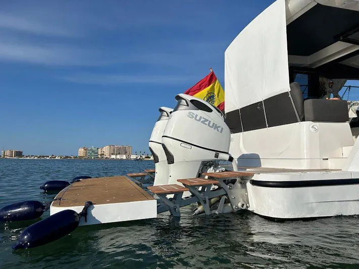  Yacht Photos Pics 2024 Sealine C390V yacht with Suzuki outboard motor, docked on calm water, Spanish flag visible.