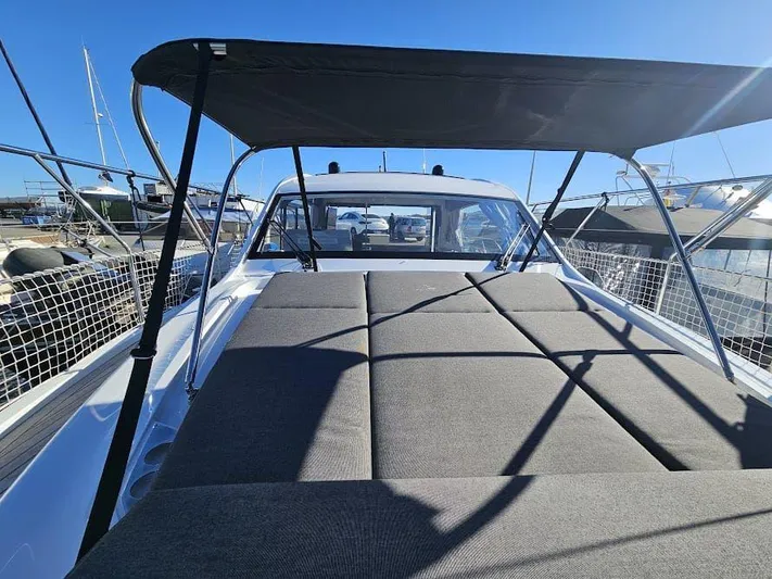  Yacht Photos Pics 2024 Sealine C390V yacht with sunshade and spacious deck, docked under clear blue sky.