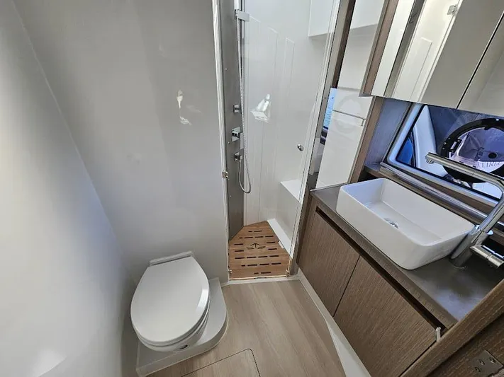  Yacht Photos Pics 2024 Sealine C390V yacht bathroom with modern fixtures, shower, and wooden cabinetry.