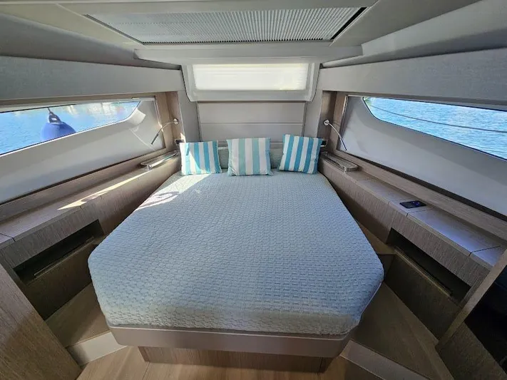  Yacht Photos Pics 2024 Sealine C390V yacht cabin with a cozy bed and striped pillows.
