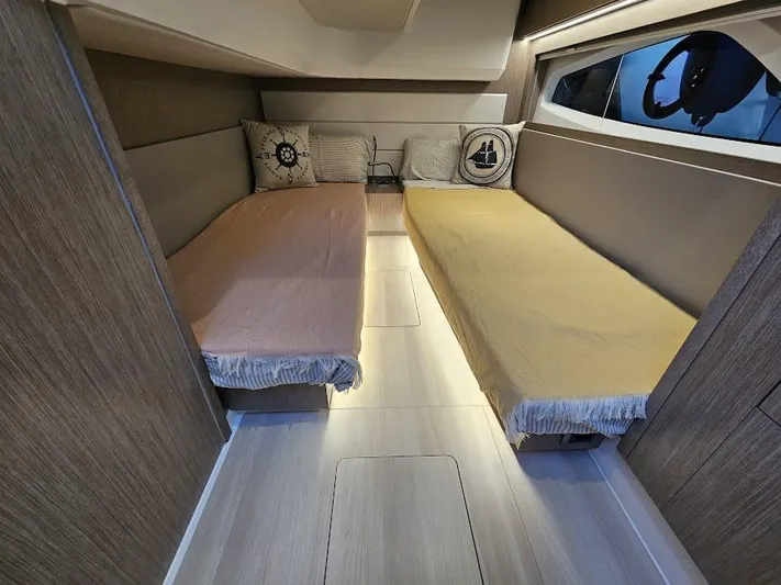  Yacht Photos Pics 2024 Sealine C390V cabin interior with twin beds and nautical-themed pillows.