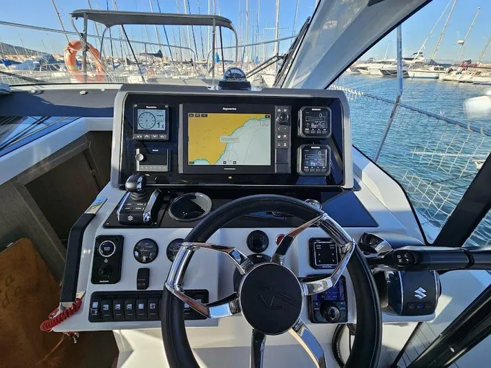  Yacht Photos Pics 2024 Sealine C390V yacht cockpit with navigation system and steering wheel, docked at marina.