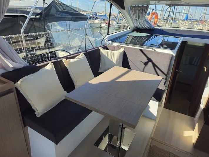  Yacht Photos Pics 2024 Sealine C390V yacht interior with cozy seating and dining area, docked at marina.