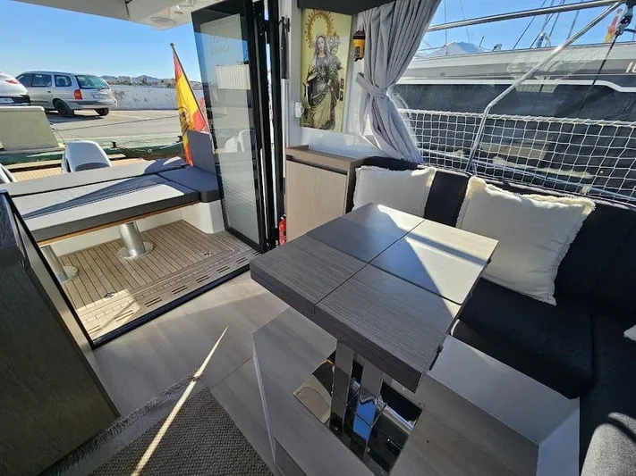  Yacht Photos Pics 2024 Sealine C390V yacht interior with modern seating, table, and decor, featuring a Spanish flag.