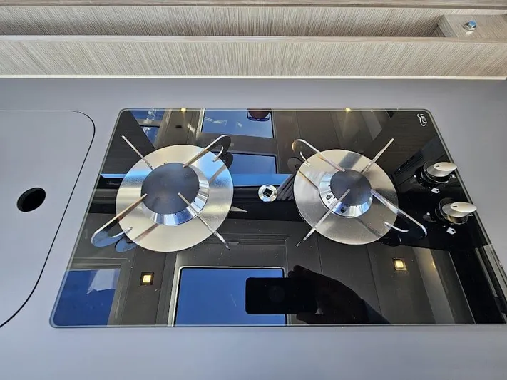  Yacht Photos Pics Modern stovetop on 2024 Sealine C390V yacht, featuring sleek dual burners and reflective glass surface.