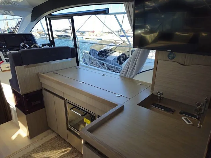  Yacht Photos Pics 2024 Sealine C390V yacht interior with modern kitchen, sleek cabinetry, and marina view.