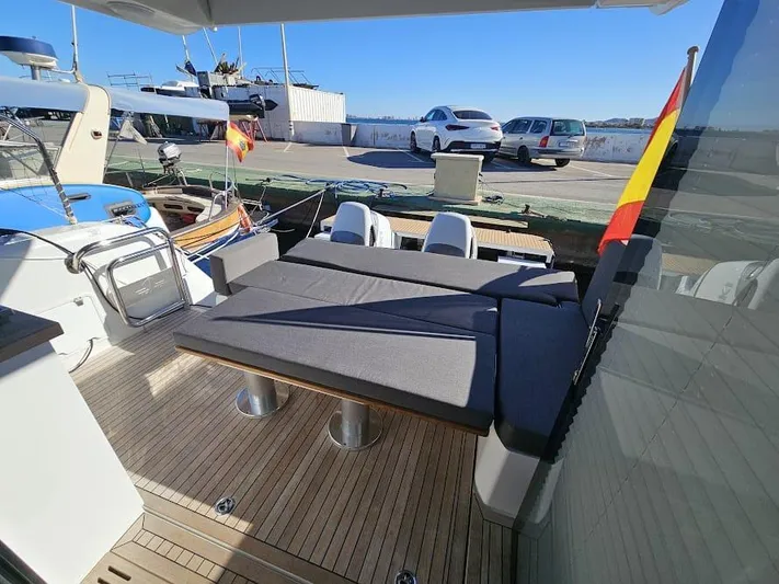  Yacht Photos Pics 2024 Sealine C390V yacht deck with seating, docked at marina under clear blue sky.