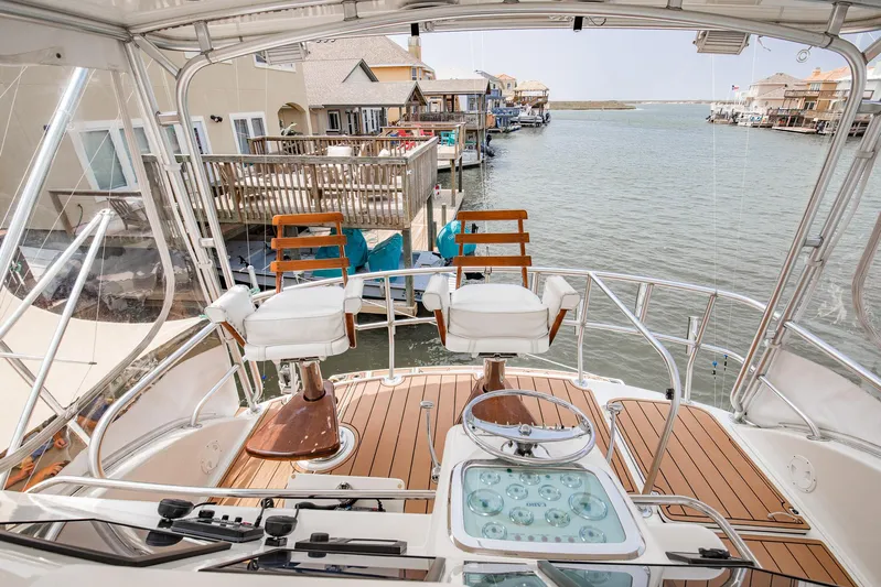 High Interest Yacht Photos Pics 2002 Cabo Convertible Painted boat with wooden deck and waterfront view.