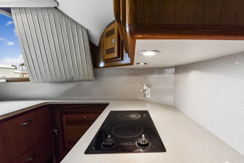 High Interest Yacht Photos Pics 2002 Cabo Convertible Painted yacht kitchen with stovetop and wooden cabinets.