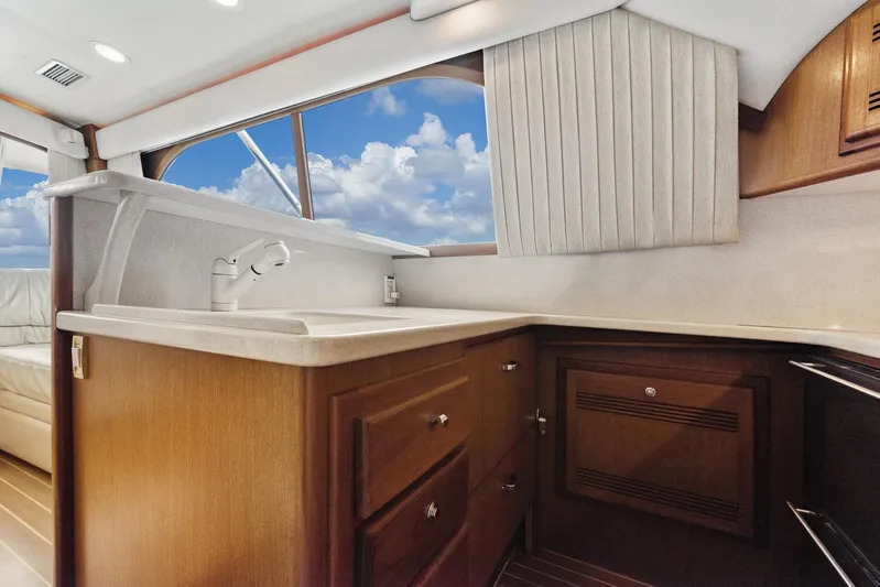 High Interest Yacht Photos Pics 2002 Cabo Convertible Painted yacht kitchen with wooden cabinets and ocean view.