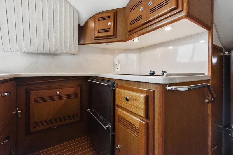 High Interest Yacht Photos Pics 2002 Cabo Convertible Painted boat kitchen with wooden cabinets and modern appliances.