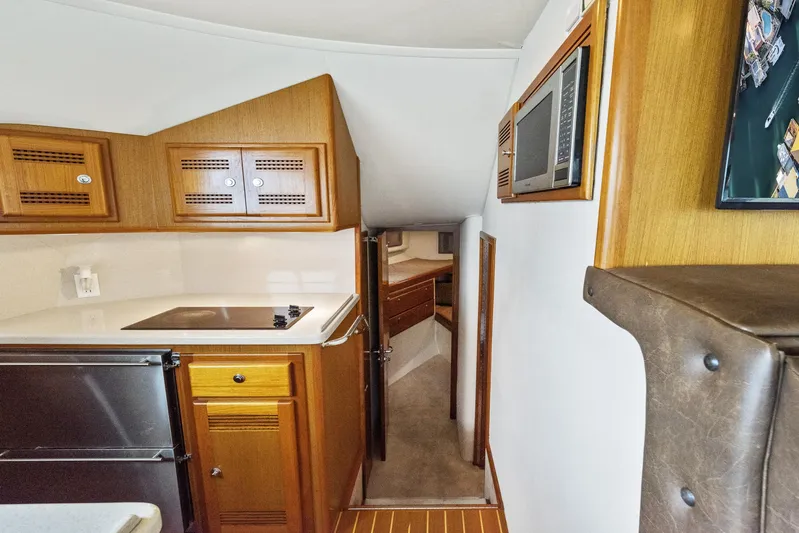 High Interest Yacht Photos Pics 2002 Cabo Convertible Painted boat interior with kitchenette and hallway to sleeping quarters.