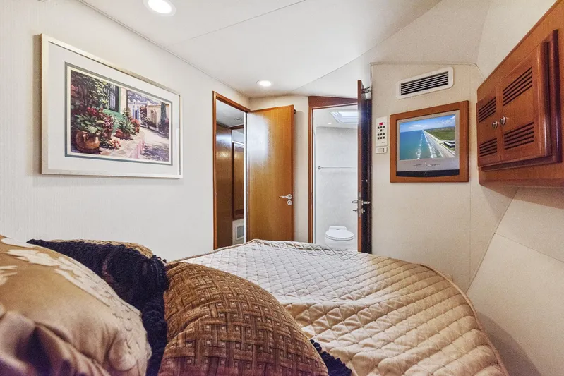 High Interest Yacht Photos Pics 2002 Cabo Convertible Painted yacht bedroom with TV, artwork, and ensuite bathroom.