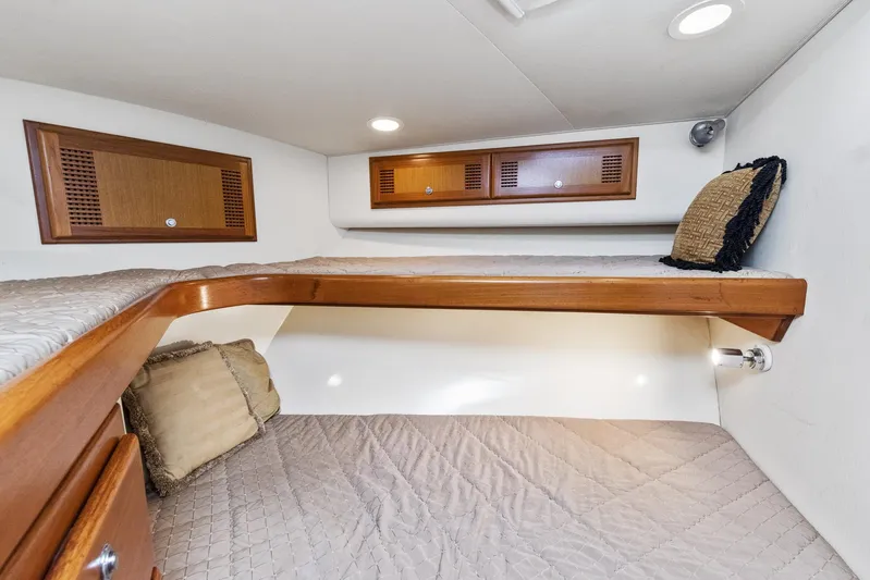 High Interest Yacht Photos Pics 2002 Cabo Convertible Painted boat interior with wooden cabinets and cozy bedding.
