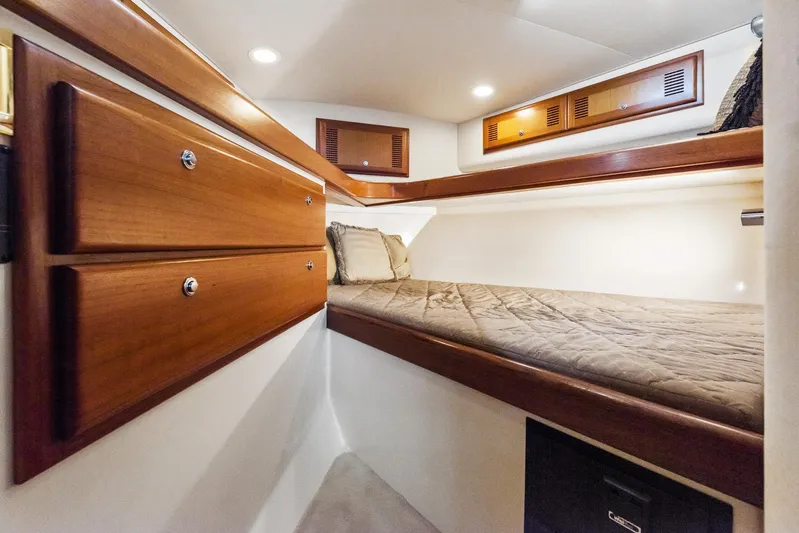 High Interest Yacht Photos Pics 2002 Cabo Convertible Painted boat interior with wooden cabinets and cozy bed.