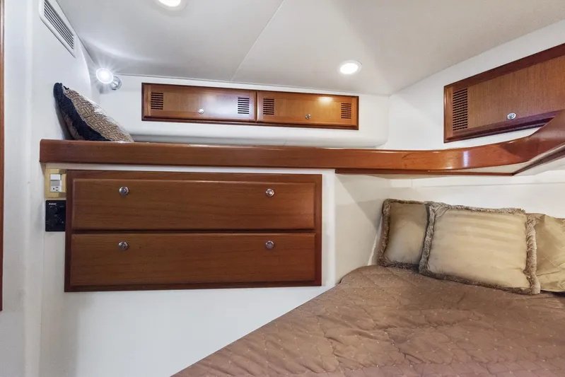 High Interest Yacht Photos Pics 2002 Cabo Convertible Painted boat interior with wooden cabinets and cozy bedding.