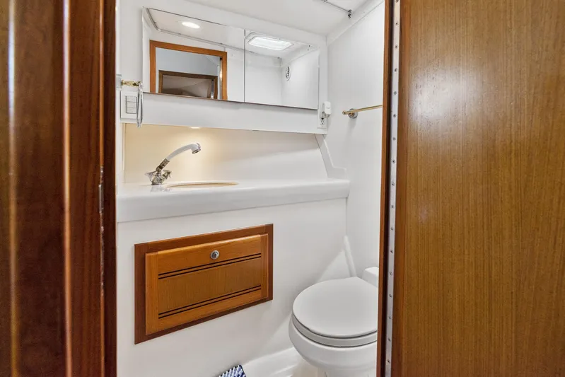 High Interest Yacht Photos Pics 2002 Cabo Convertible Painted boat bathroom with sink, mirror, and toilet.