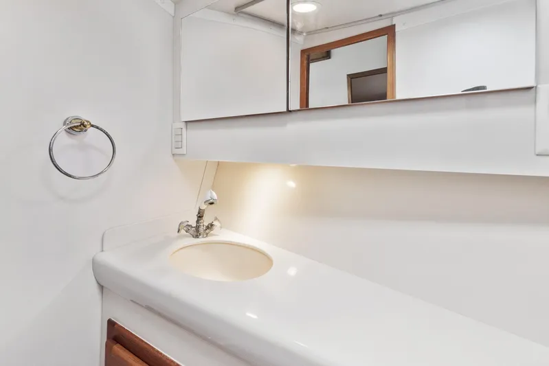 High Interest Yacht Photos Pics 2002 Cabo Convertible Painted boat bathroom with white sink and mirror.